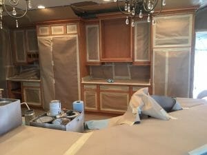 Masking and taping ahead of the job -- simply white kitchen cabinets, with glaze and custom mixed color to complete the look. The result is a stunning example of the quality kitchen refinishing services offered by Richie's Refinishing.