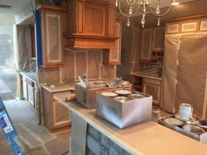 At the start of every refinishing project, we tape and mask the area to avoid overspray and maintain a clean workspace. Kitchen cabinets to be refinished in simply white.